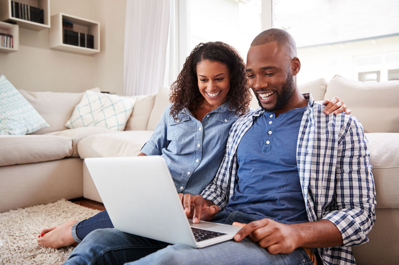 couple working on laptop in living room