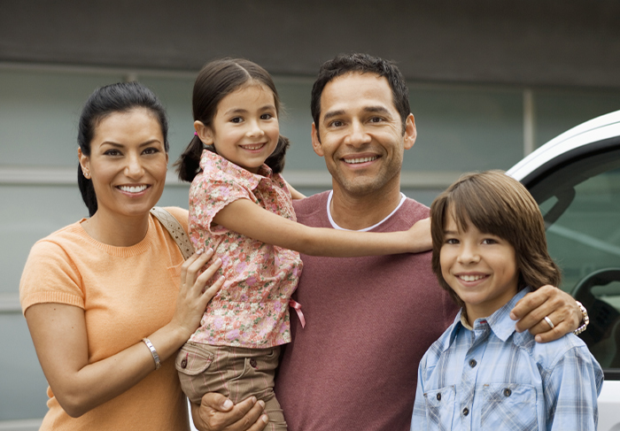 family in front of car