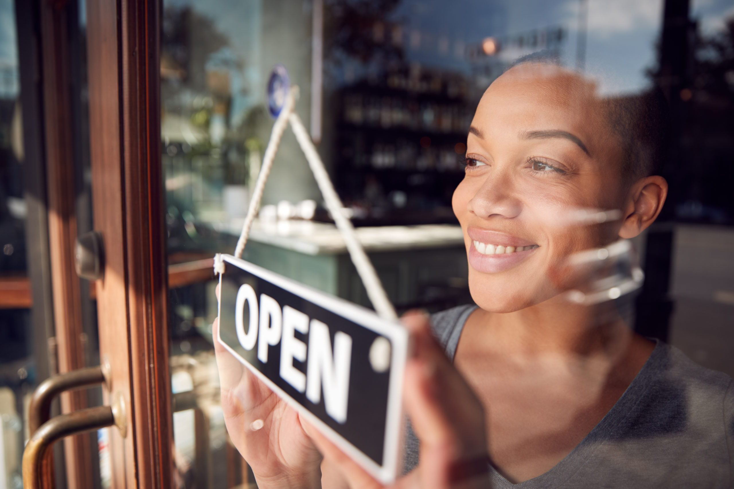 do you need commercial umbrella insurance? image shows business owner at the door of her business