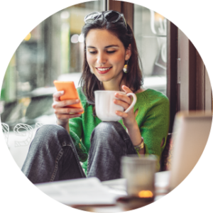 woman in coffee shop, looking at phone while working in fall