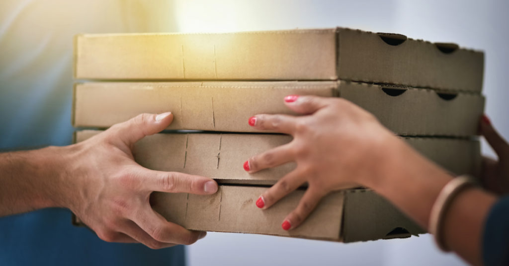 restaurant handing takeout order to customer