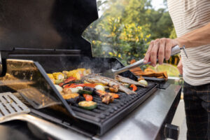 Person grilling in backyard