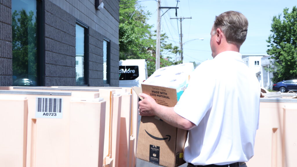 Merchants President Charles Makey carries boxes into FeedMore WNY warehouse