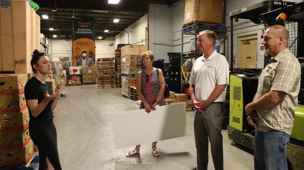 Caitlin Evans, Donor Engagement Director of FeedMore WNY, with Merchants’ Janice Wojtanik, Charles Makey, and Matt Sedita at FeedMore WNY warehouse