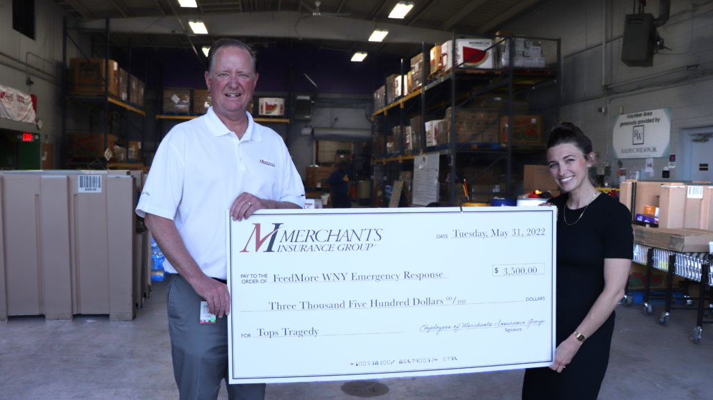 Charles Makey, Merchants Insurance Group, and Caitlin Evans, FeedMore WNY, with Merchants donation check