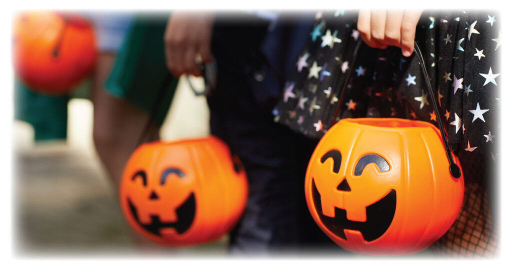 Children holding pumpkin buckets as they trick-or-treat on Halloween