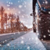 photo of car tire driving on snowy road to indicate driving in unpredictable weather