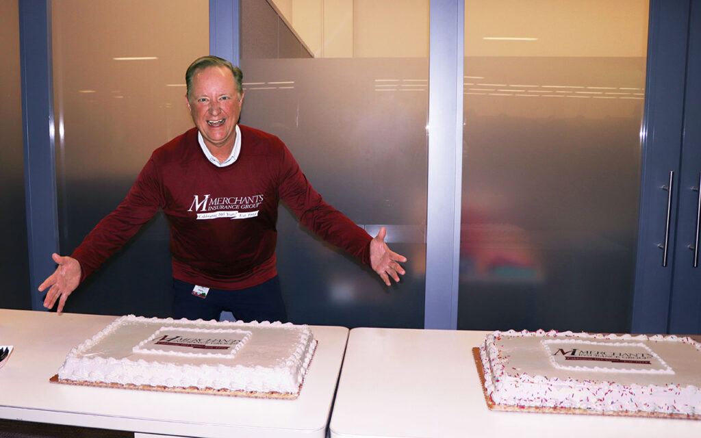 Merchants Insurance Group President Charles Makey poses with cake at Merchants' 105th anniversary celebration!