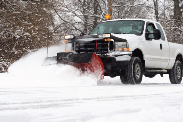White truck snow plow driving on snowy road, snow plow business at work during winter